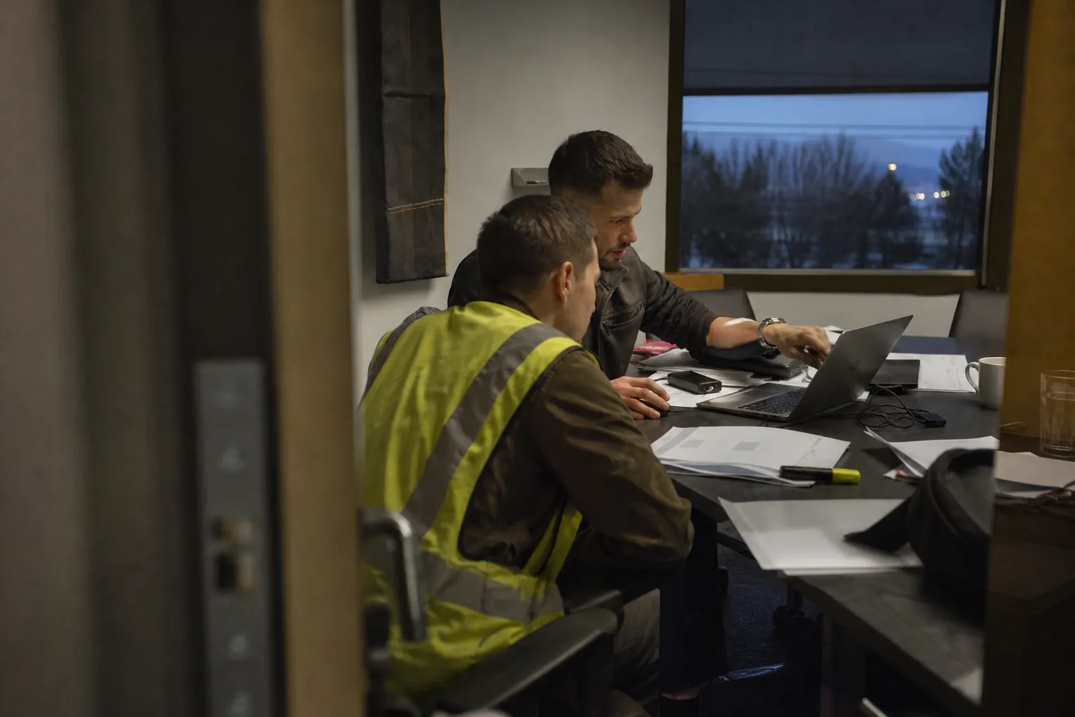 Client operations lead and onboarding manager reviewing a new statement of work at a crowded table