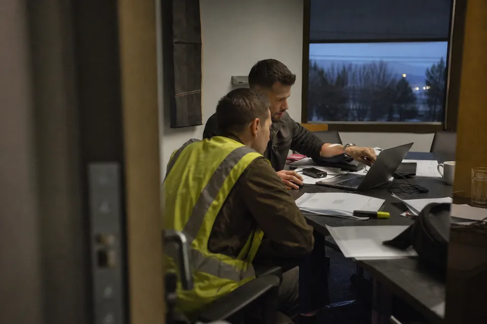 Client operations lead and onboarding manager reviewing a new statement of work at a crowded table