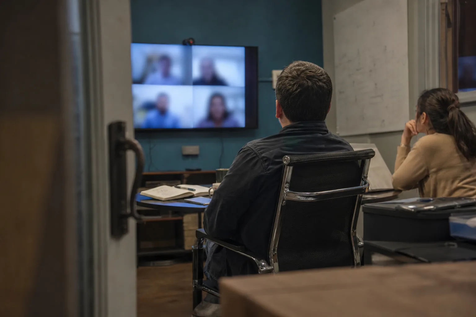 Customer project lead joining a kickoff video call from a meeting room
