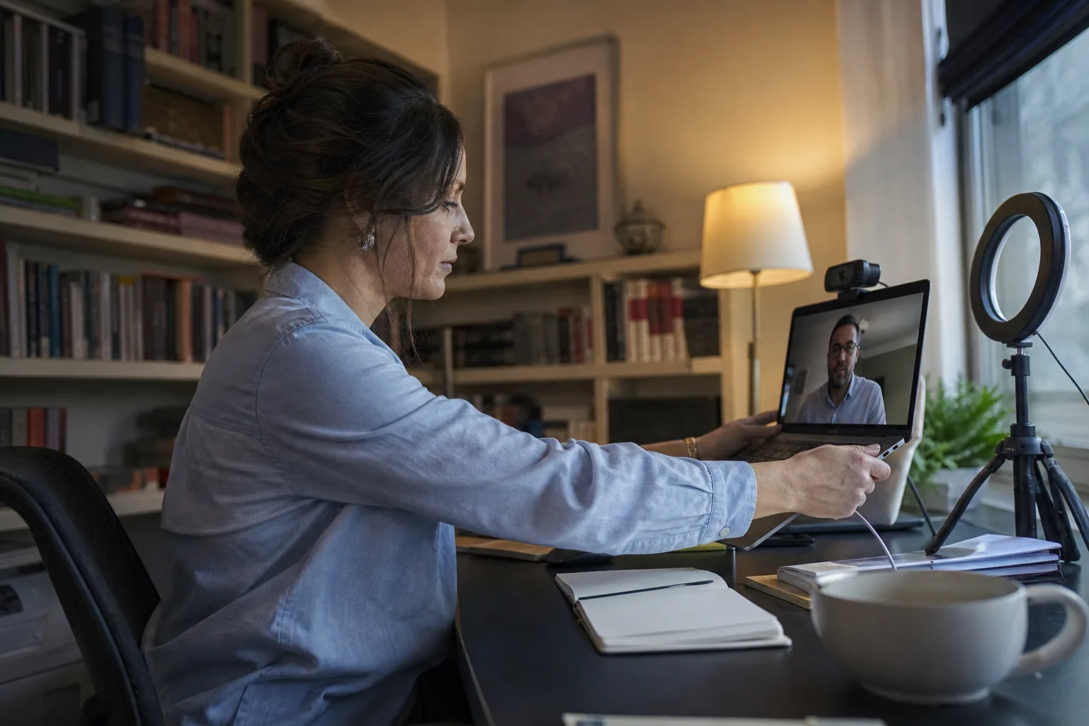 Independent consultant sharing a client portal on a laptop during a video call from a home studio